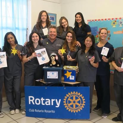 Dental hygiene students with certificates and a Club Rotario Rosarito banner